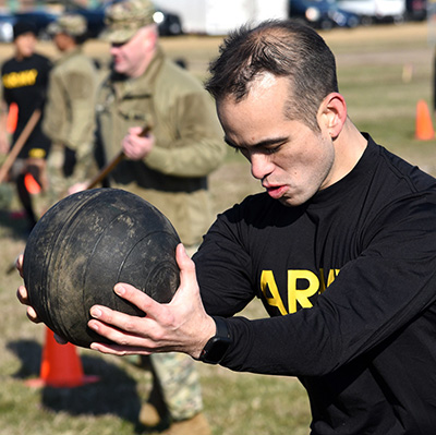 Army man training with medicine ball in his hands